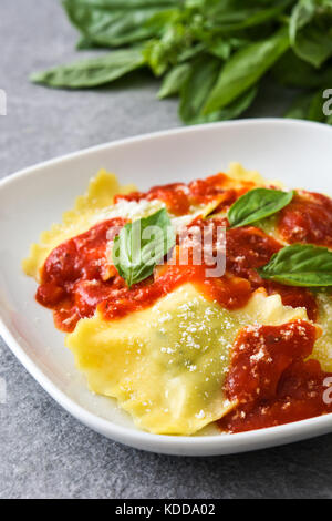 Ravioli à la sauce tomate et basilic sur pierre gris Banque D'Images