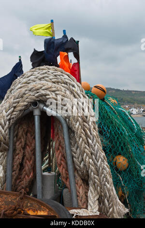 Les engins de pêche, marqueur drapeaux, filets, cordes et flotteurs entassés sur le quai sur le Cobb à Lyme Regis dans le Dorset. Banque D'Images