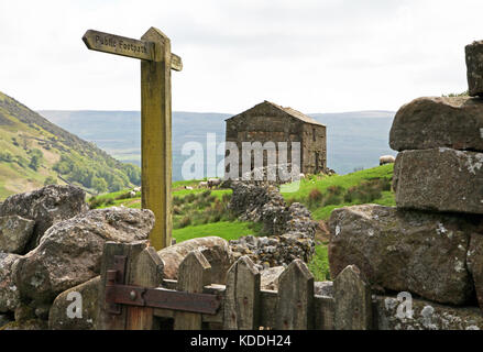 Panneau public pour les sentiers pédestres, grange en pierre et murs en pierre sèche près du village d'Angram à Swaledale. Banque D'Images