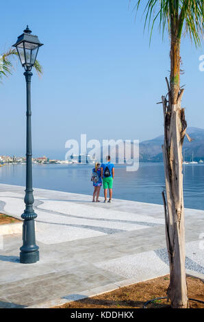 Argostoli Grèce couple sur la promenade du port à côté à des tortues caouannes, Céphalonie, Céphalonie, îles Ioniennes, Grèce. Banque D'Images