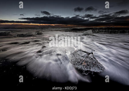 La glace sur Breidamerkursandur Plage de sable noir, au coucher du soleil, l'Islande Jokulsarlon Banque D'Images