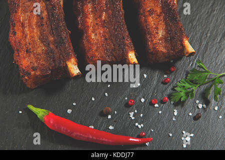 Côtes de porc frit avec des pommes de terre sur une surface en pierre Banque D'Images
