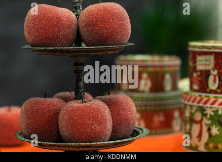 Pommes rouges décoratifs dans le brillant du sucre des miettes sur une plaque sur un fond sombre libre de la nouvelle année Banque D'Images