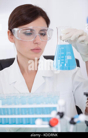 Female scientist looking at chemical dans le ballon Banque D'Images
