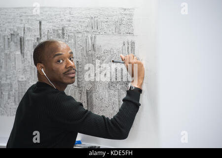 New York, New York, USA. 13 oct, 2017. L'artiste de renom Stephen wiltshire continue dimensions l'empire state building et la ville de New York à partir de la mémoire à l'empire state building à new york. À la suite d'un vol en hélicoptère de 45 minutes autour de Manhattan, Wiltshire va dessiner un paysage urbain à partir d'aujourd'hui à dimanche, Octobre 15, 2017, culminant avec une cérémonie de signature, le lundi, Octobre 16, 2017. wiltshire crée sa célèbre œuvre de mémoire et fera de cette pièce en résidence sur le 80e étage de l'empire state building. l'artiste basé à Londres, les progrès seront visibles pour observatory Banque D'Images