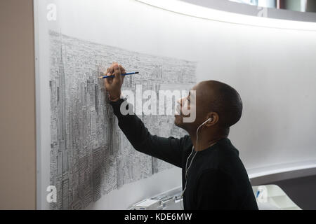 New York, New York, États-Unis. 13 octobre 2017. Le célèbre artiste STEPHEN WILTSHIRE continue de dessiner l'Empire State Building et New York City de mémoire à l'Empire State Building le 13 octobre 2017 à New York. Après un vol en hélicoptère de 45 minutes autour de Manhattan, le Wiltshire dessinera un paysage urbain d'aujourd'hui au dimanche 15 octobre 2017, pour culminer avec une cérémonie de signature le lundi 16 octobre 2017. Wiltshire crée son œuvre d'art de mémoire et fera cette pièce en résidence au 80ème étage de l'Empire State Building. Le progrès de l'artiste basé à Londres sera v Banque D'Images