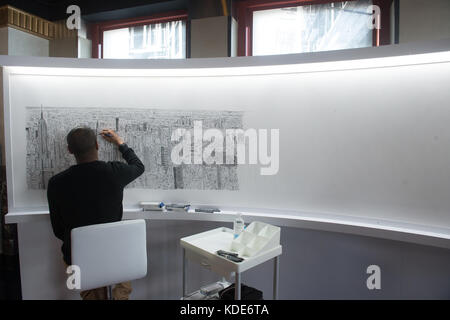 New York, New York, États-Unis. 13 octobre 2017. Le célèbre artiste STEPHEN WILTSHIRE continue de dessiner l'Empire State Building et New York City de mémoire à l'Empire State Building le 13 octobre 2017 à New York. Après un vol en hélicoptère de 45 minutes autour de Manhattan, le Wiltshire dessinera un paysage urbain d'aujourd'hui au dimanche 15 octobre 2017, pour culminer avec une cérémonie de signature le lundi 16 octobre 2017. Wiltshire crée son œuvre d'art de mémoire et fera cette pièce en résidence au 80ème étage de l'Empire State Building. Le progrès de l'artiste basé à Londres sera v Banque D'Images