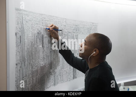 New York, New York, États-Unis. 13 octobre 2017. Le célèbre artiste STEPHEN WILTSHIRE continue de dessiner l'Empire State Building et New York City de mémoire à l'Empire State Building le 13 octobre 2017 à New York. Après un vol en hélicoptère de 45 minutes autour de Manhattan, le Wiltshire dessinera un paysage urbain d'aujourd'hui au dimanche 15 octobre 2017, pour culminer avec une cérémonie de signature le lundi 16 octobre 2017. Wiltshire crée son œuvre d'art de mémoire et fera cette pièce en résidence au 80ème étage de l'Empire State Building. Le progrès de l'artiste basé à Londres sera v Banque D'Images