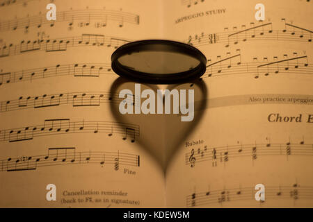 L'ombre en forme de coeur sur une musique vintage feuille sous la lumière d'une lampe Banque D'Images