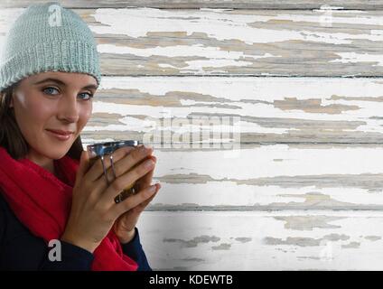 Digital composite of Woman contre le bois avec écharpe et chapeau et tasse Banque D'Images