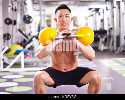 Asian male bodybuilder travaillant dans l'aide de sport électrique des cloches. Banque D'Images