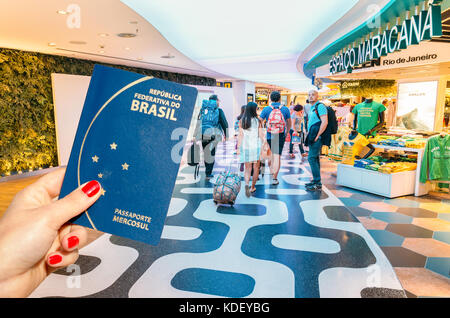 Main tenant un passeport brésilien avec un 5 reais remarque à l'intérieur. à l'intérieur de l'inter de rio Banque D'Images