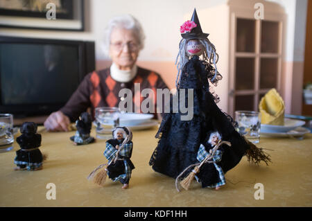 De l'épiphanie et Halloween des poupées heureux d'un séjour sur une table en bois avec grand-mère sourit en arrière-plan. Florence, Italie Banque D'Images