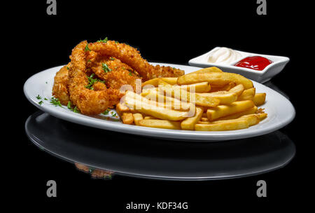 Bâtonnets de poisson frit servi avec des frites sur une assiette blanche isolé sur un fond noir Banque D'Images