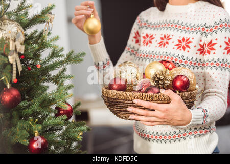 Girl decorating Christmas Tree Banque D'Images