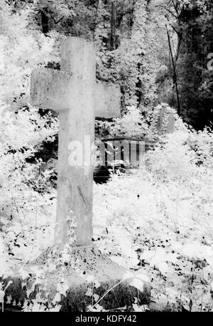 Un port infrarouge tourné d'un vieux cimetière, la pierre, la croix. Banque D'Images