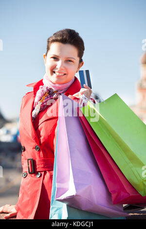 Woman holding shopping bags et montrant une carte de crédit à l'avant de la tour spasskaya Banque D'Images