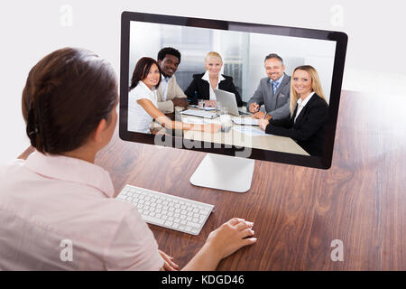 Businesswoman assis à un bureau à regarder une présentation en ligne sur l'ordinateur Banque D'Images