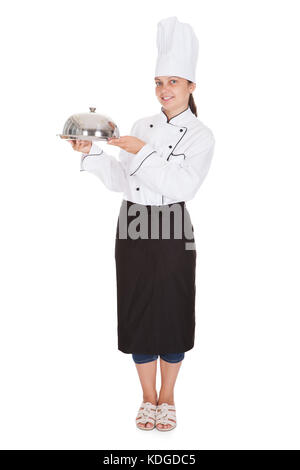 Portrait of female chef holding plateau sur fond blanc Banque D'Images