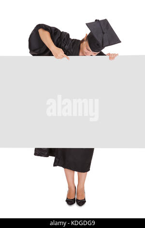 Graduate woman holding blank placard sur fond blanc Banque D'Images