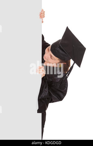 Graduate woman holding blank placard sur fond blanc Banque D'Images