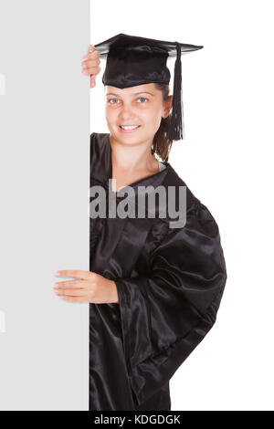 Graduate woman holding blank placard sur fond blanc Banque D'Images