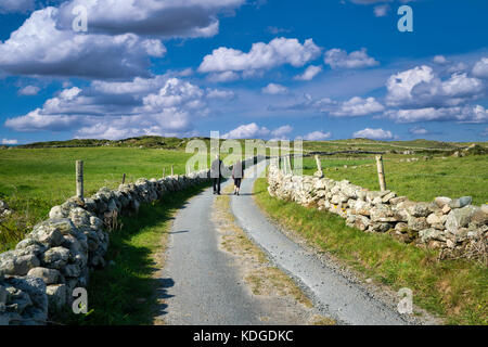 Couple walking on road sur omey island. connemara comté de Galway, Irlande, Banque D'Images