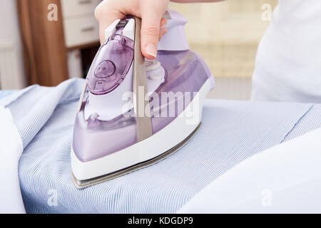 Close-up of woman ironing clothes sur table à repasser Banque D'Images