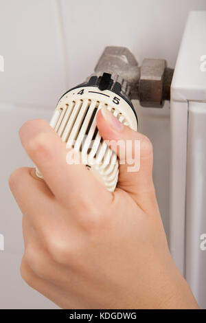 Close-up of Person's Hand Réglage de température par thermostat Banque D'Images