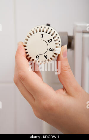 Close-up of Person's Hand Réglage de température par thermostat Banque D'Images