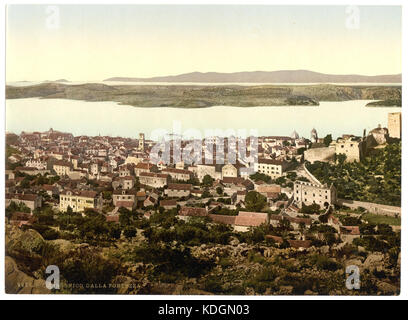 Cette image montre la vue de Sebenico (aujourd'hui Šibenik) depuis le fort, situé dans la région de Dalmatie. L'image donne un aperçu de l'architecture historique et du paysage de la région. Banque D'Images