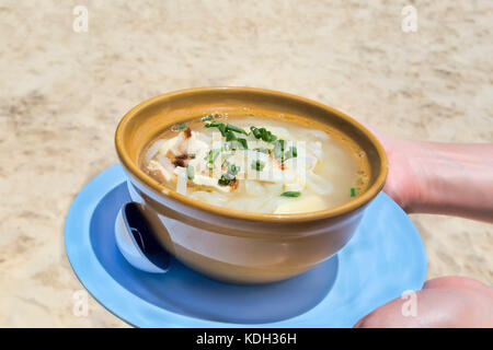 Soupe poulet et nouilles thaï sur la plage - selective focus Banque D'Images