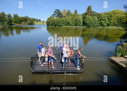 Les visiteurs utilisent le Chain Ferry ou le Rope Ferry à travers le lac, conçu par Capability Brown, à Compton Verney House, Warwickshire, Angleterre Banque D'Images