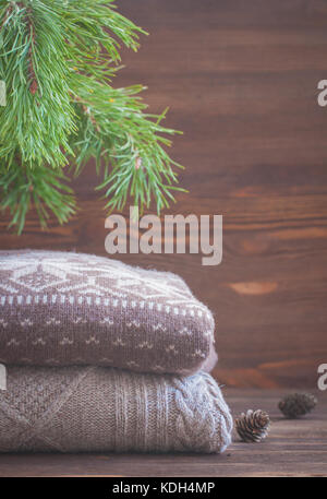 Pile de vêtements d'hiver en tricot beige sur fond de bois, pulls, tricots, de l'espace pour le texte Banque D'Images