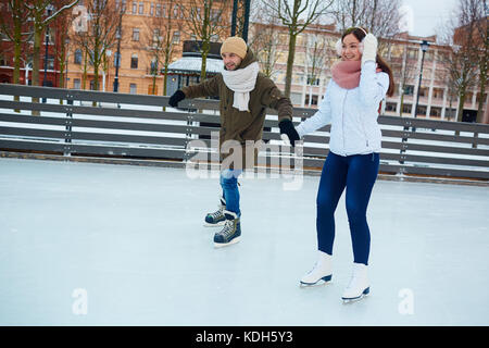 Couple amoureux en patins et vêtements de profiter de loisirs sur patinoire Banque D'Images