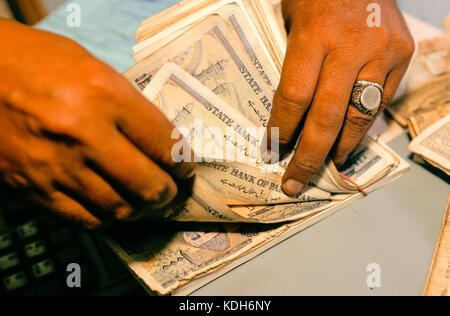 Mains comptant la monnaie pakistanaise avec des billets de la Banque d'État du Pakistan. Banque D'Images