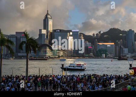 Tsim Sha Tsui, Kowloon, Hong Kong - 2 octobre 2017 : Journée nationale des personnes en attente d'artifice dans la pluie au bord de mer de Victoria Harbour Banque D'Images