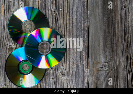 Trois cd sur disque en bois sombre tableau. Vue de dessus la texture du bois. Banque D'Images