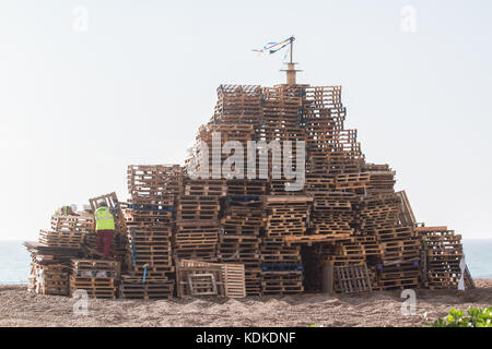 Hastings, East Sussex, UK. 14 octobre 2017. Les travailleurs des caisses de pile sur la plage à Hastings pour préparer le Bonfire Night le 5 novembre également connu sous le nom de nuit des feux d'artifice qui est une tradition britannique datant de la conspiration de 1605, lorsque le conspirateur catholique Guy Fawkes a tenté de faire exploser la maison du parlement crédit : amer ghazzal/Alamy live news Banque D'Images