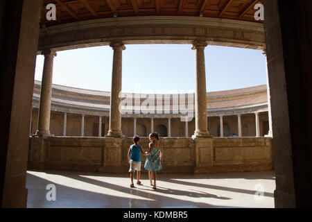 Grenade Alhambra, Patio de Charles V (Carlos V) Palace - deux enfants de touristes se rendant sur le dernier passage de Maure Banque D'Images