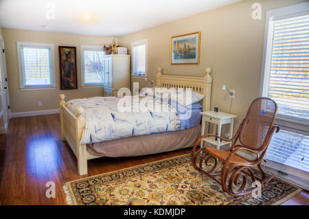 Chambre avec lit à baldaquin, une table de chevet, ventilateur de plafond, de parquet et d''une salle de bains privative attenante dans un quartier accueil dans le Vermont, aux États-Unis. Banque D'Images