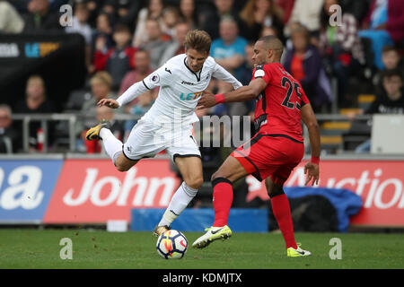 Mathias Jorgensen (à droite) de la ville de Huddersfield s'est fouillé Tom Carroll de Swansea City lors du match de la première ligue au Liberty Stadium, à Swansea. Banque D'Images