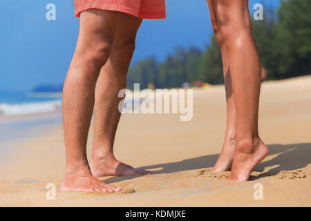 Pattes d'un couple s'embrasser dans l'amour sur une plage de la mer Banque D'Images