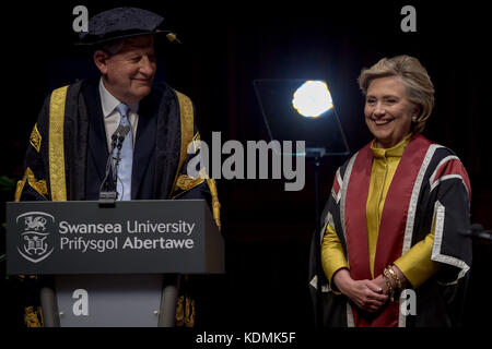 Hillary Clinton plaisantait avec le professeur Richard Davies, vice-chancelier, alors qu'elle reçoit un doctorat honorifique à l'Université Swansea, en reconnaissance de son engagement à promouvoir les droits des familles et des enfants dans le monde entier,Un engagement partagé par l'Observatoire des droits de l'enfant et des jeunes de l'Université Swansea. Banque D'Images