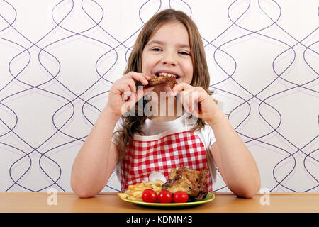 Hungry girl eating chicken wings Banque D'Images