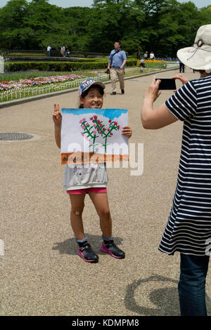 Kyoto, Japon - 21 mai 2017 : enfant est montrant une peinture faite par elle-même dans le jardin botanique de kyoto pour apprendre la forme de fleurs et plantes Banque D'Images