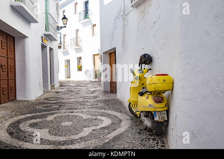 Scooter dans ruelle de Frigiliana, promenade journalière pour les visiteurs de la station balnéaire de la Costa del Sol dans le sud de l'Espagne. Banque D'Images