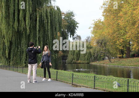 Garçon prend une photo ou une vidéo d'une jeune fille à Regents Park. adolescents mucking autour. Banque D'Images