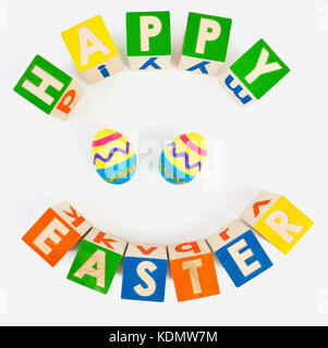 Joyeuses pâques message avec blocs de jouets dans un motif de cercles et des oeufs en plastique colorés. isolés. Banque D'Images