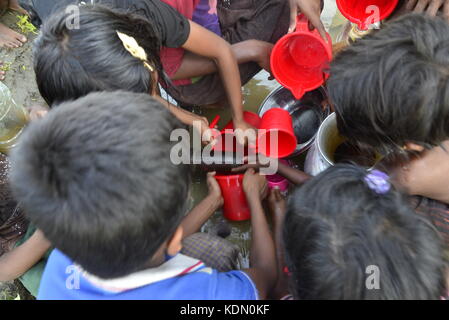 Enfants Rohingyas sont recueille l'eau de la rizière à l'balukhali camp à Cox's bazar, Bangladesh, le 10 octobre 2017 selon l'ONU. Banque D'Images
